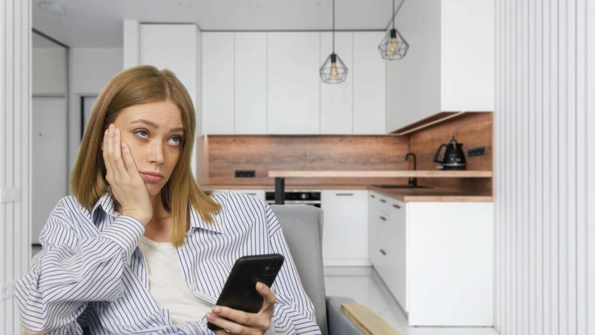 Young bored woman watching smartphone