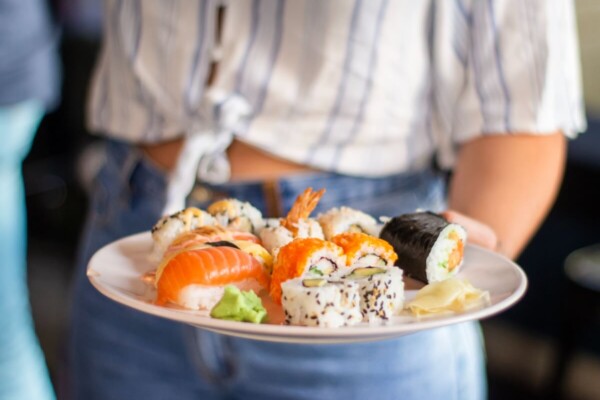 Woman holding a plate of sushi