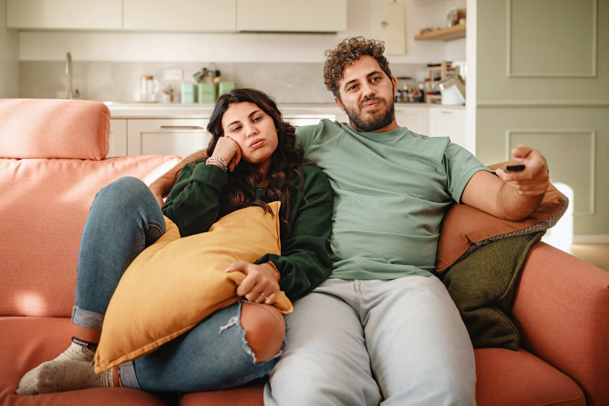 Bored couple watching tv