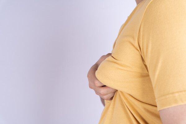 Overweight man holding breast tissue