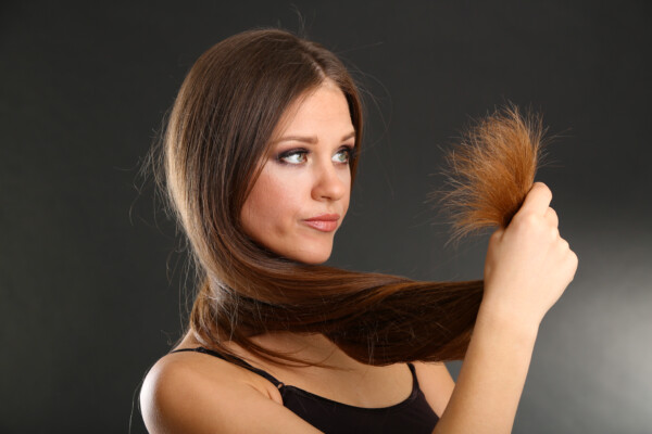 A woman looking at her split ends