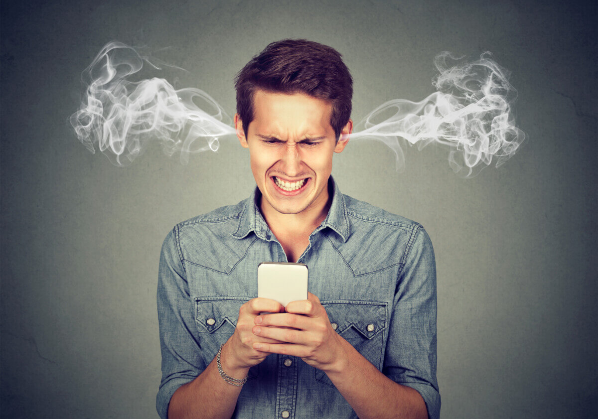 Angry man texting or using social media on smartphone