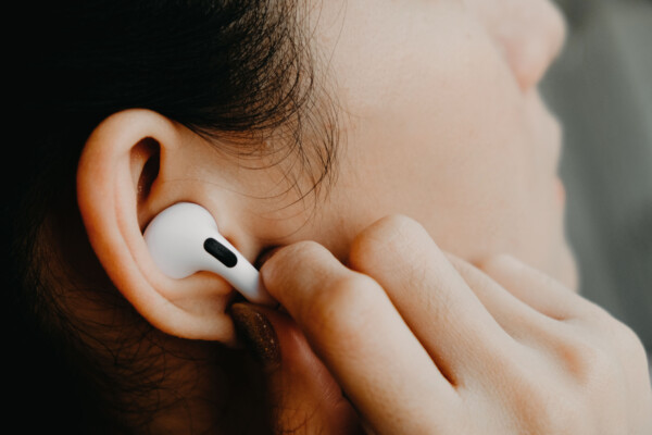 Woman adjusts her Apple AirPods Pro ear buds.