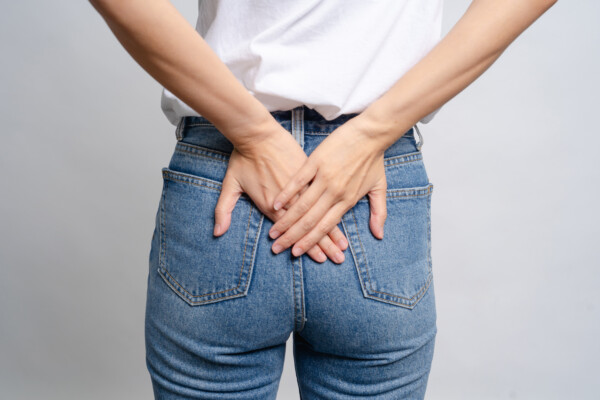 woman uses hands to touch her butt