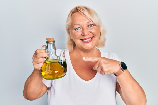 Woman holding an olive oil carafe