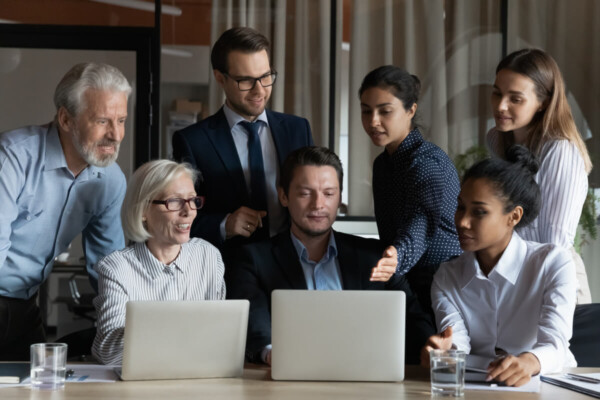 Coworkers gather in conference room for office meeting