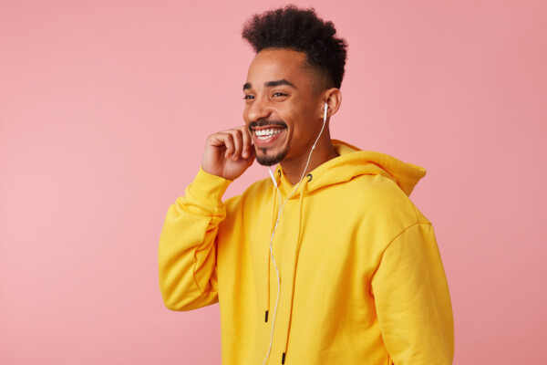 A man laughing while listening to a podcast