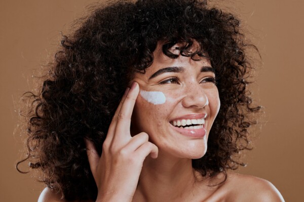 A woman applying face sunscreen