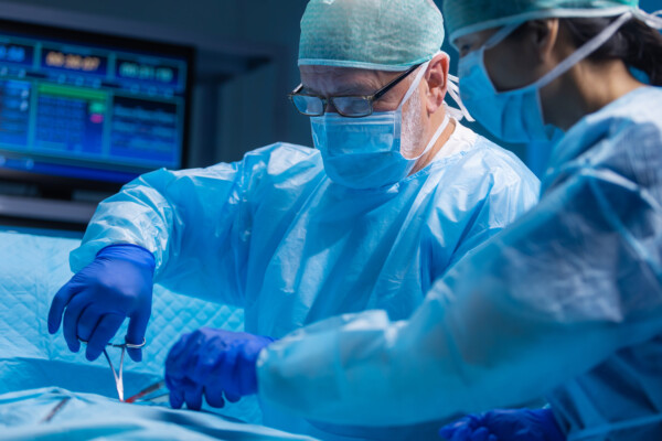 Older male surgeon performing surgery