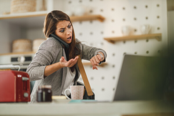 Woman running late for work, looking at her watch in shock
