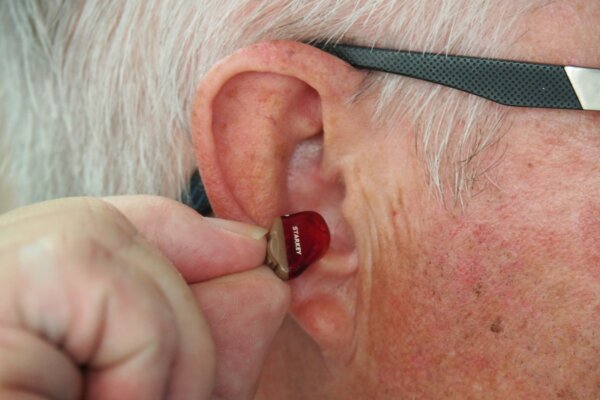 older adult with hearing aid