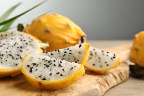 cut yellow dragon fruit (pitahaya) on wooden board