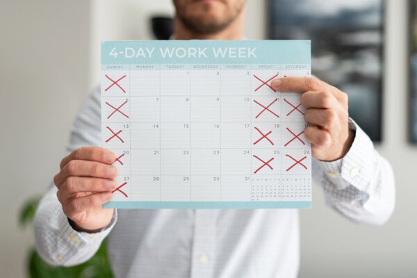 Man holding a calendar pointing to a 4-day work week
