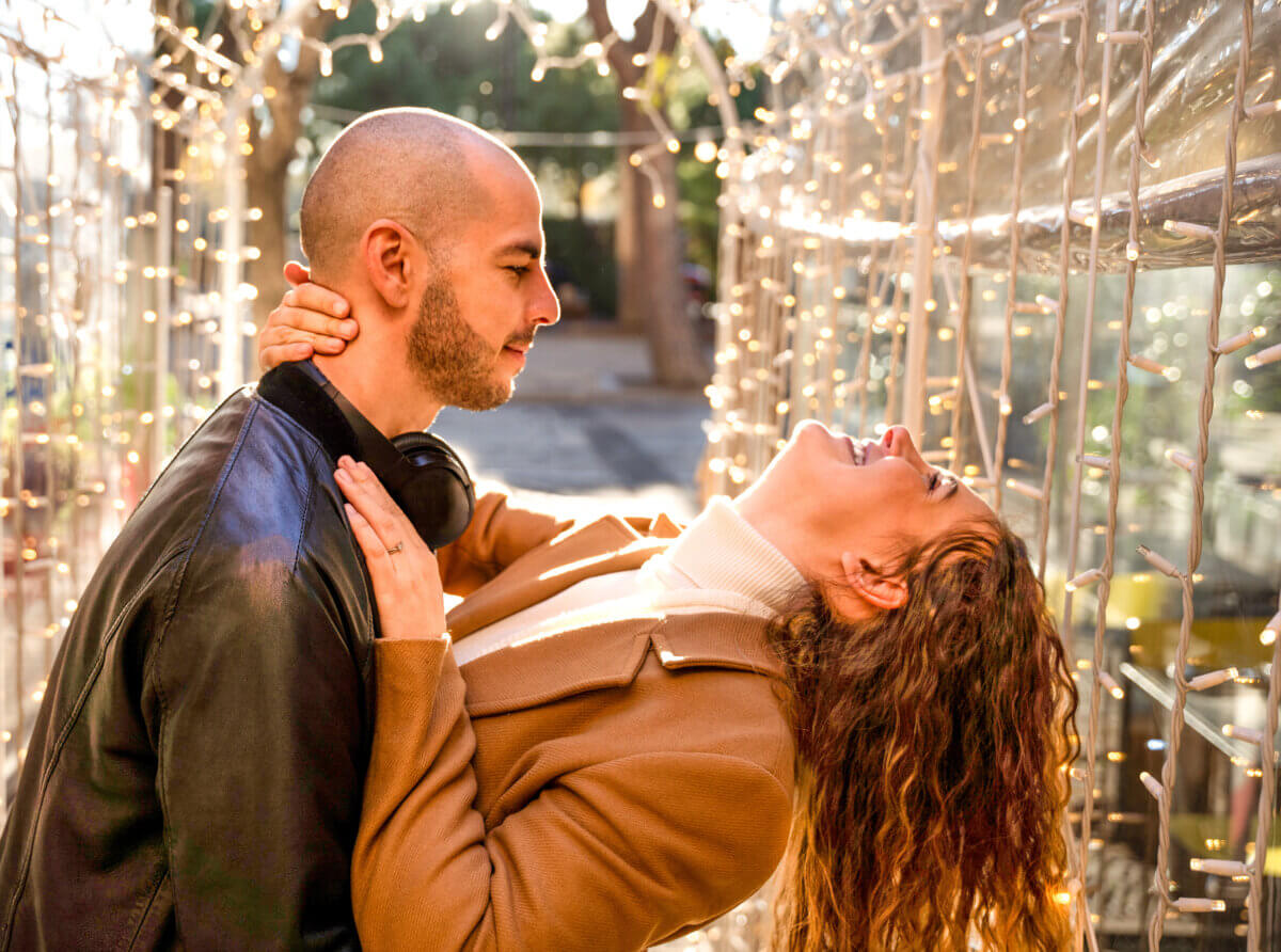 Younger Gen Z man with millennial woman in relationship, dancing outside
