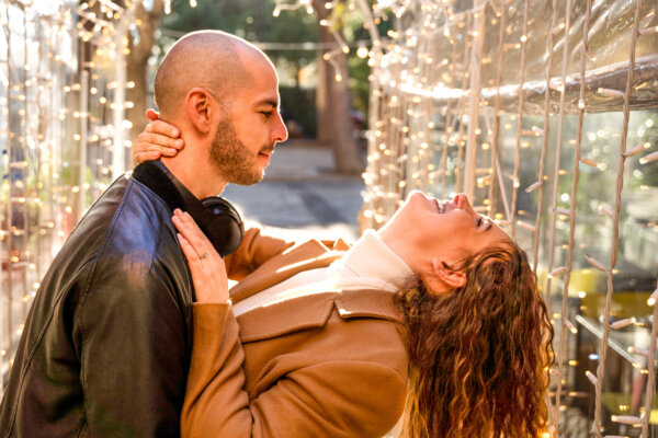 Younger Gen Z man with millennial woman in relationship, dancing outside
