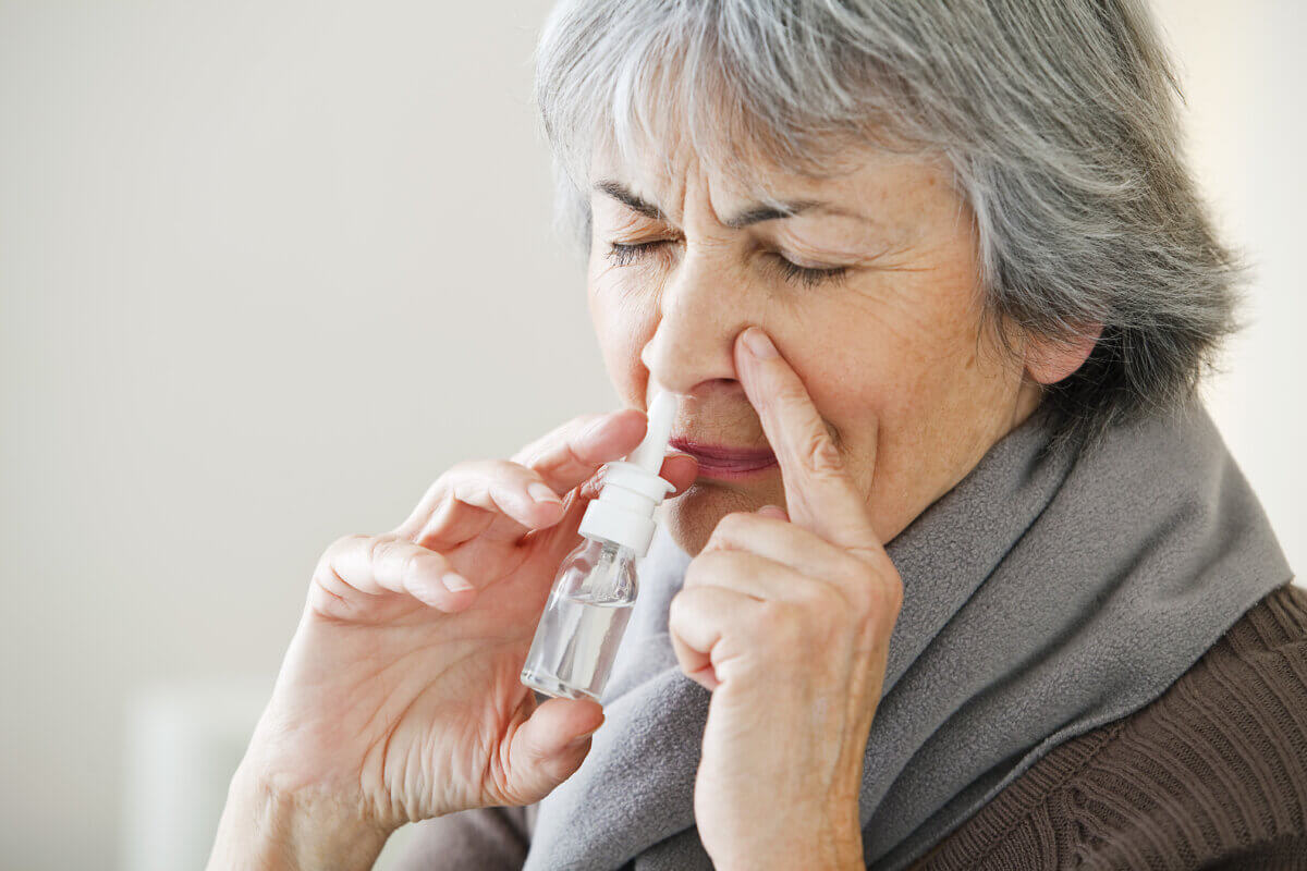 Elderly Person Using Nose Spray