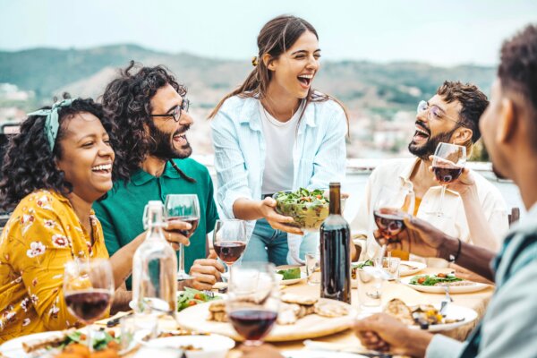 Friends and family enjoying dinner and wind outside or on vacation