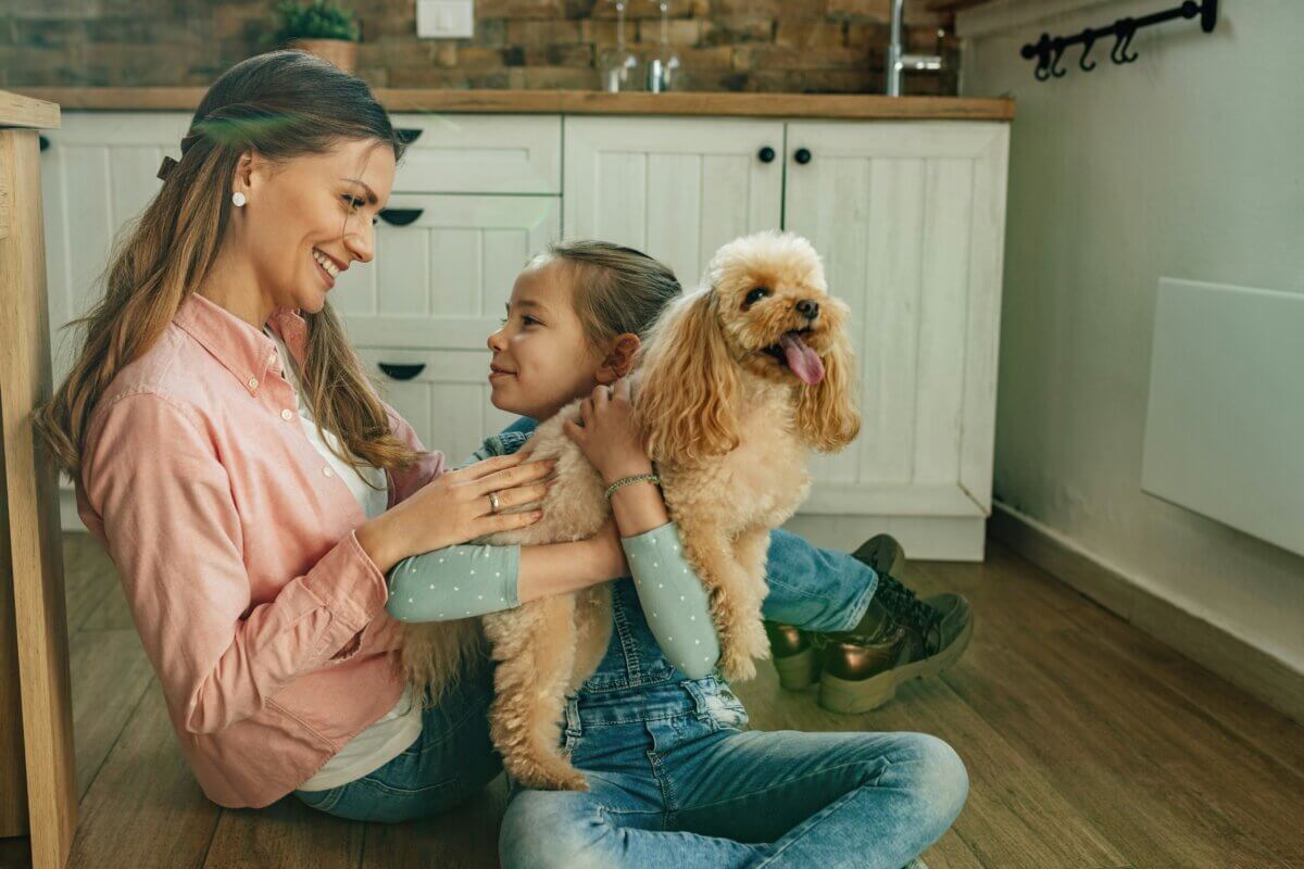 Mother and daughter hugging a puppy dog