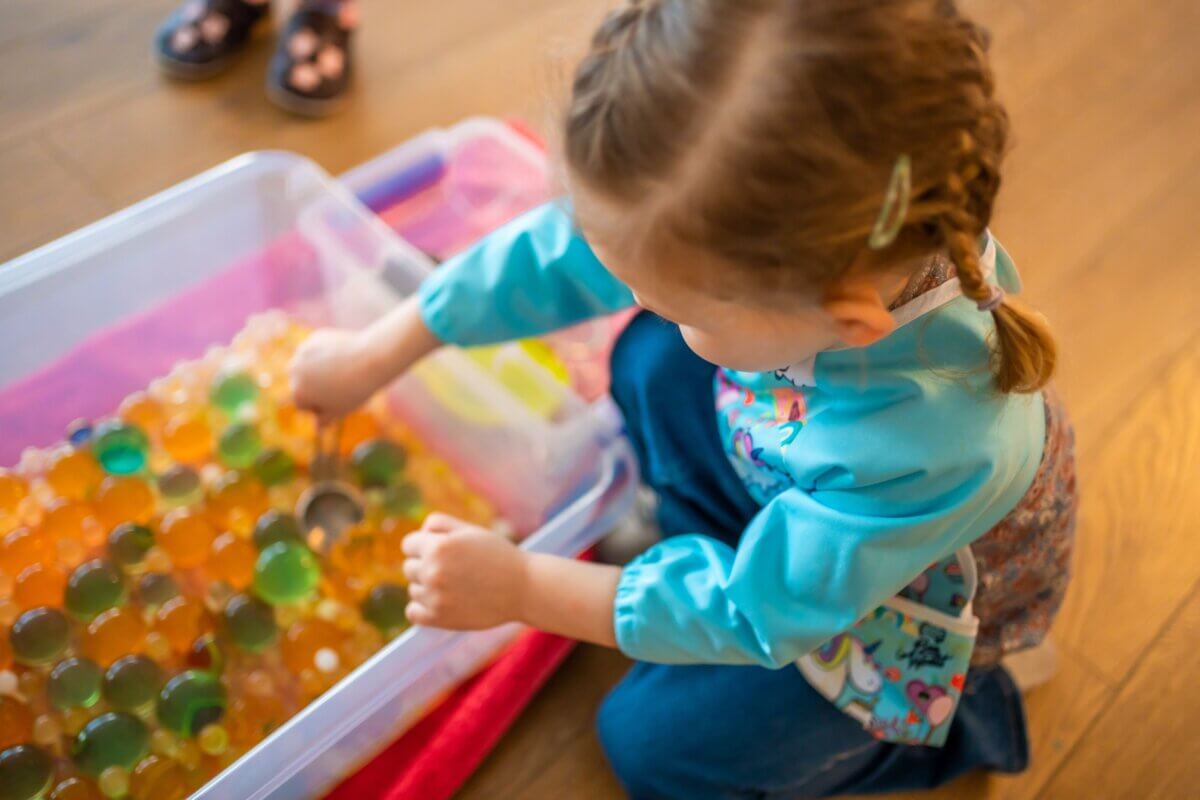 Little girl playing with sensory water beads
