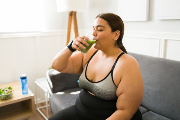 woman dieting and drinking green juice before working out