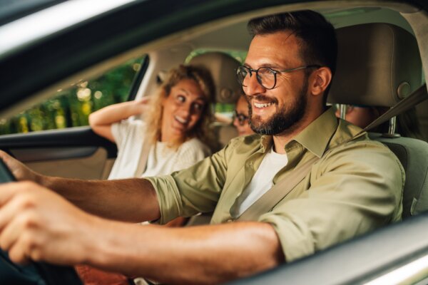 A father driving his family on a road trip