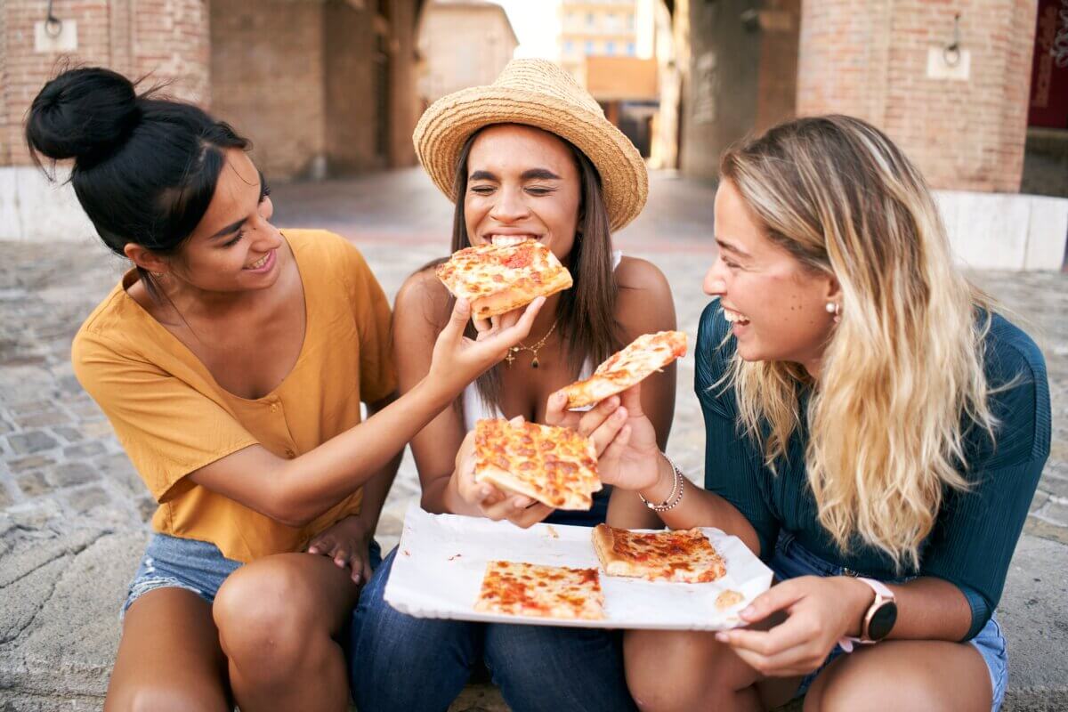 Three women enjoying pizza in Italy