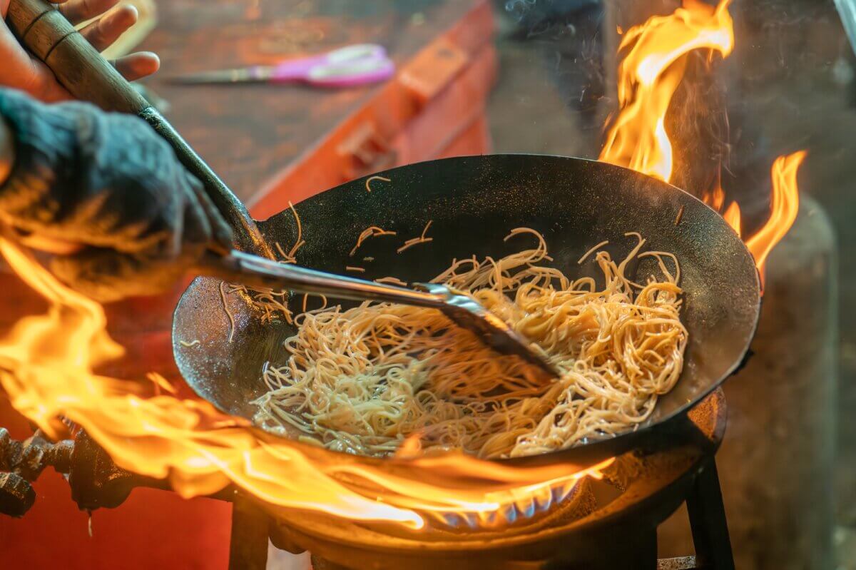 Fried noodles being prepared in a street market in Thailand