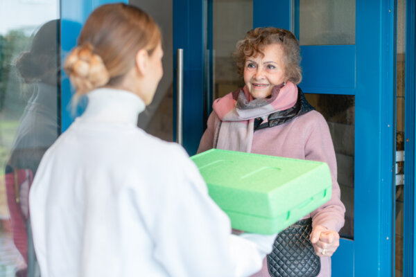 Volunteer Delivering Meal to Senior