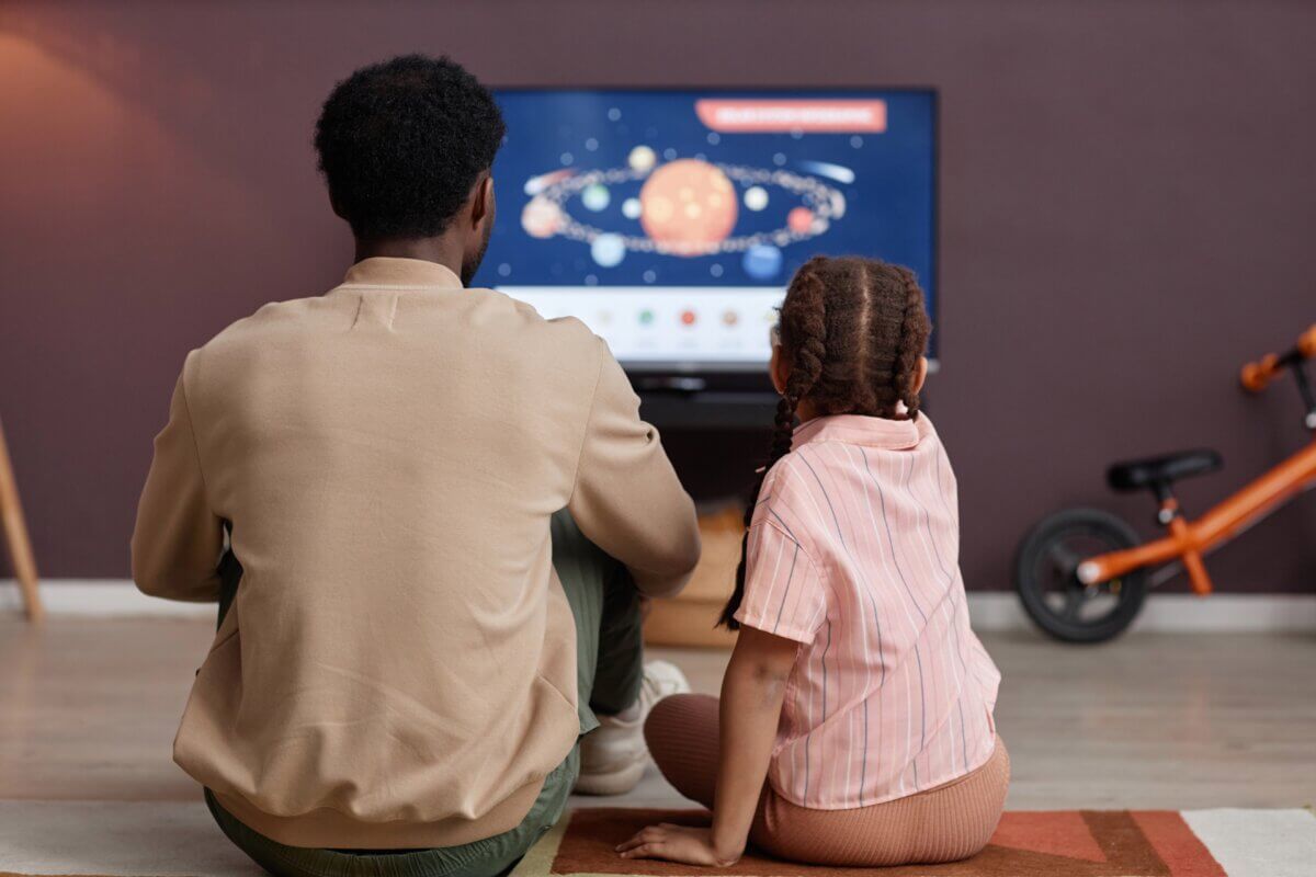 father and daughter watching television