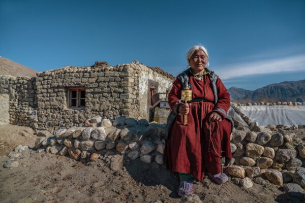 An unidentified Old buddhism tibetan women devotee holding prayer beads and wheel. Ladakh India 2019