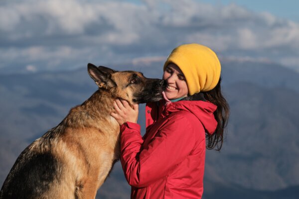 Woman laughs as her dog licks her