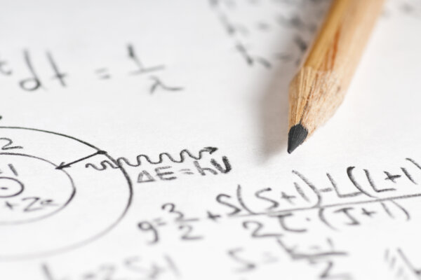 Sheet of paper filled with calculations of nuclear and quantum physics as a background