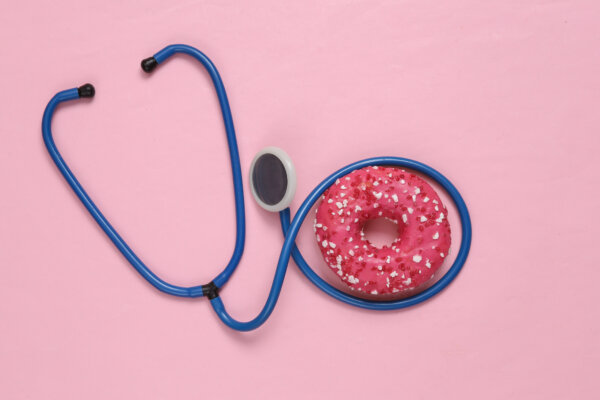 Sugar and heart health concept: Stethoscope around a donut