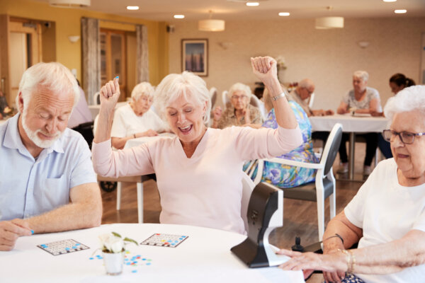 Senior woman winning game of bingo at retirement home