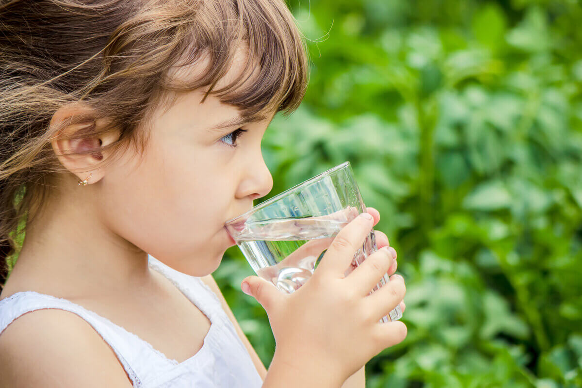 Child drinks a glass of water