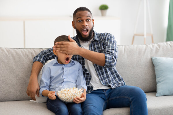 Dad and son watching scary or violent movie