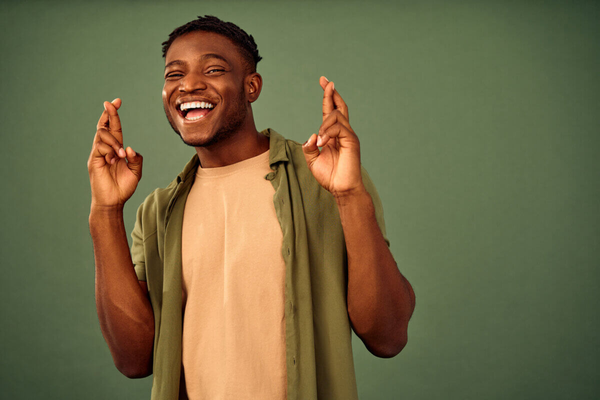 Teen or man crossing his fingers for good luck