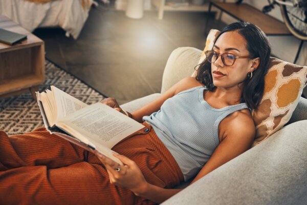 Woman reading book on couch