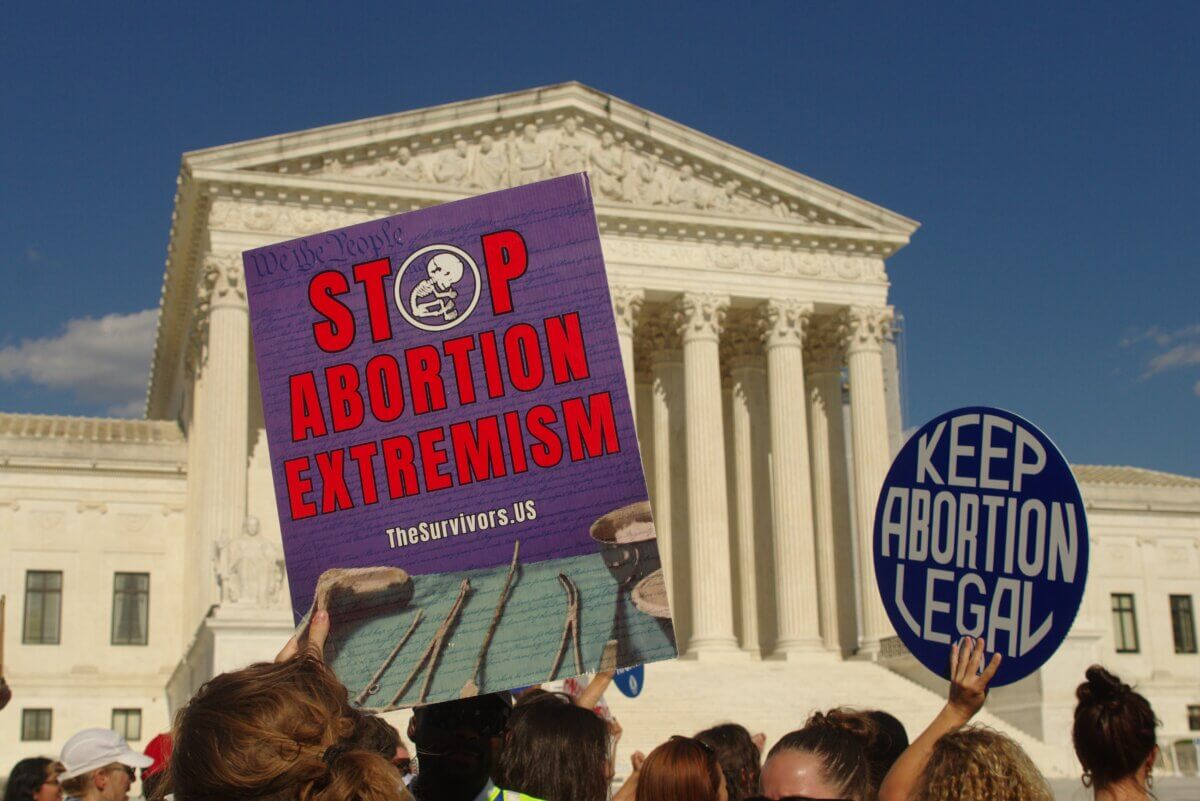 Protesters on both sides of the abortion issue hold up signs at the Supreme Court on the 2nd anniversary of the landmark Dobbs decision. 