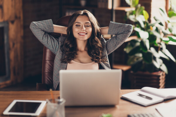 Successful, attractive business woman reclining at office desk