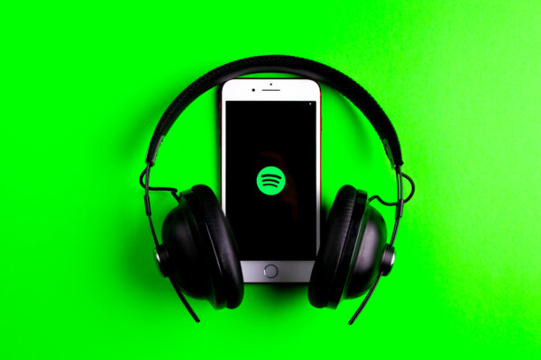 A phone opened to the Spotify app with headphones