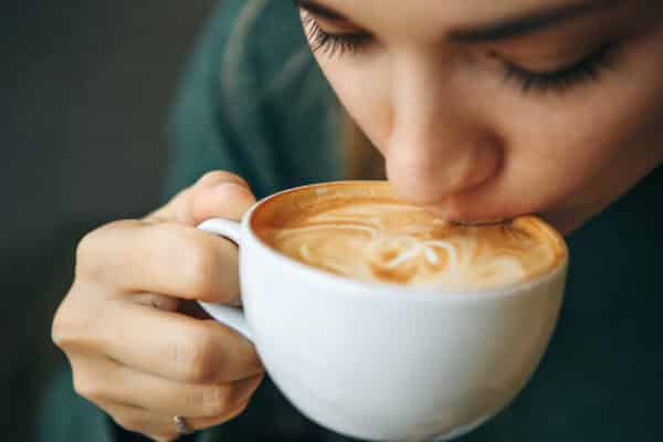 Woman takes a sip of coffee from a mug