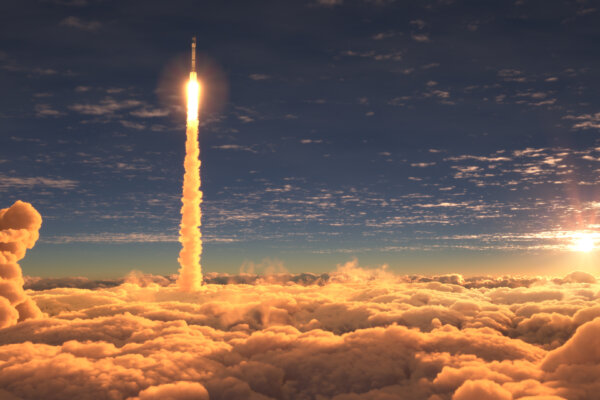 Rocket launch through clouds at sunset