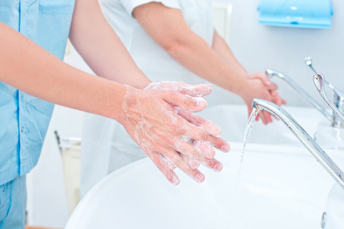 Doctors washing their hands in hospital sinks