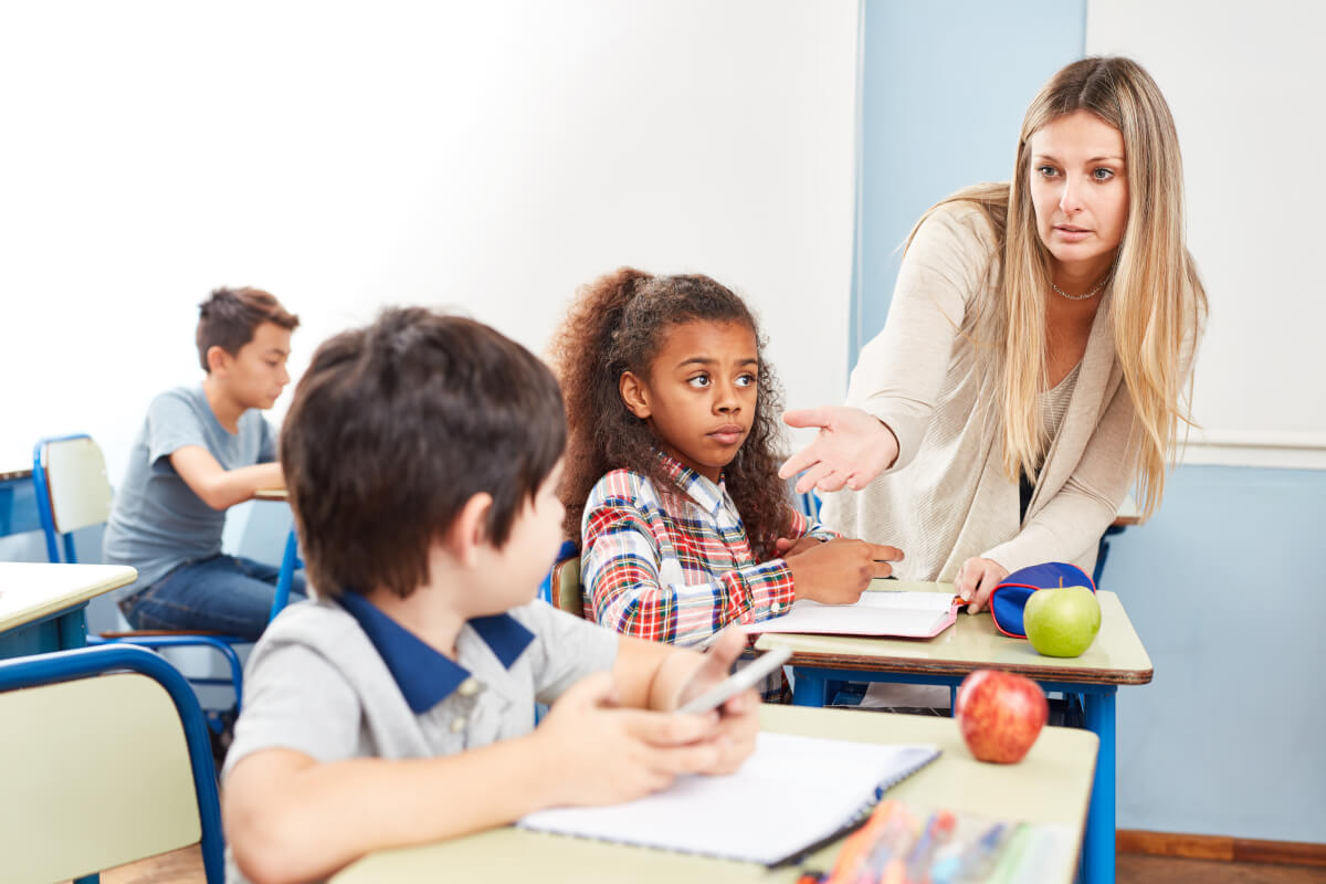 A teacher confiscating a phone from a student