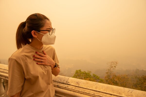 A woman wearing a mask to protect herself from wildfire smoke.