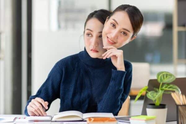 A woman wearing a metaphorical smile mask at work