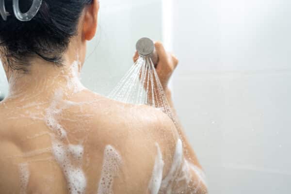 Woman washing her back and shoulders in the shower