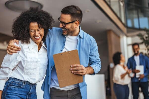 Two cheerful coworkers laughing