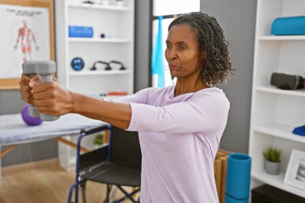 Older Black woman lifting weights